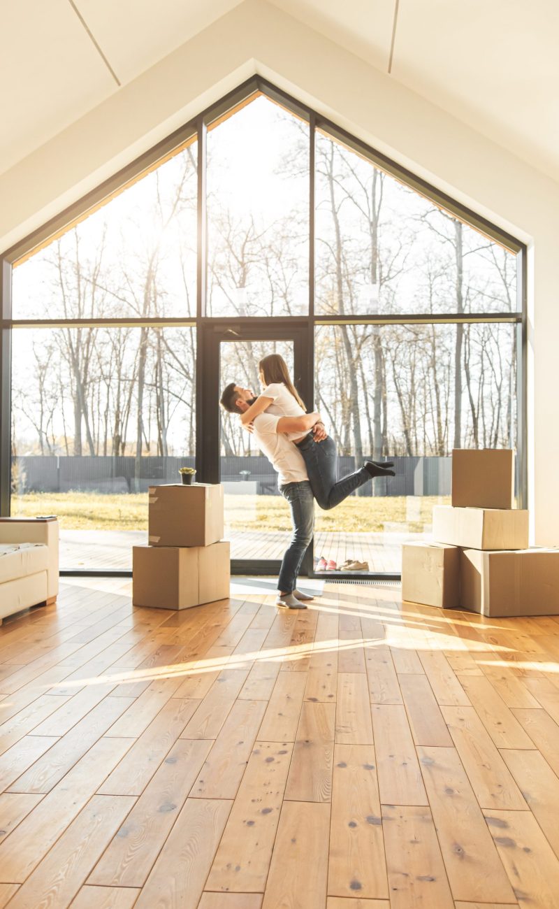 young couple moves to a new home. the family carries boxes of things after buying a second mortgage toronto